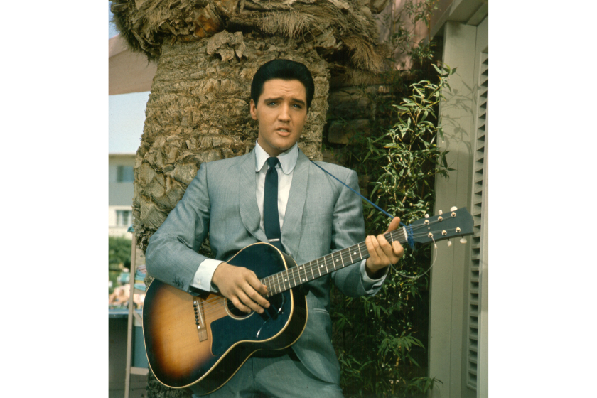 Rock and roll singer Elvis Presley strums his guitar in a movie still from circa 1964