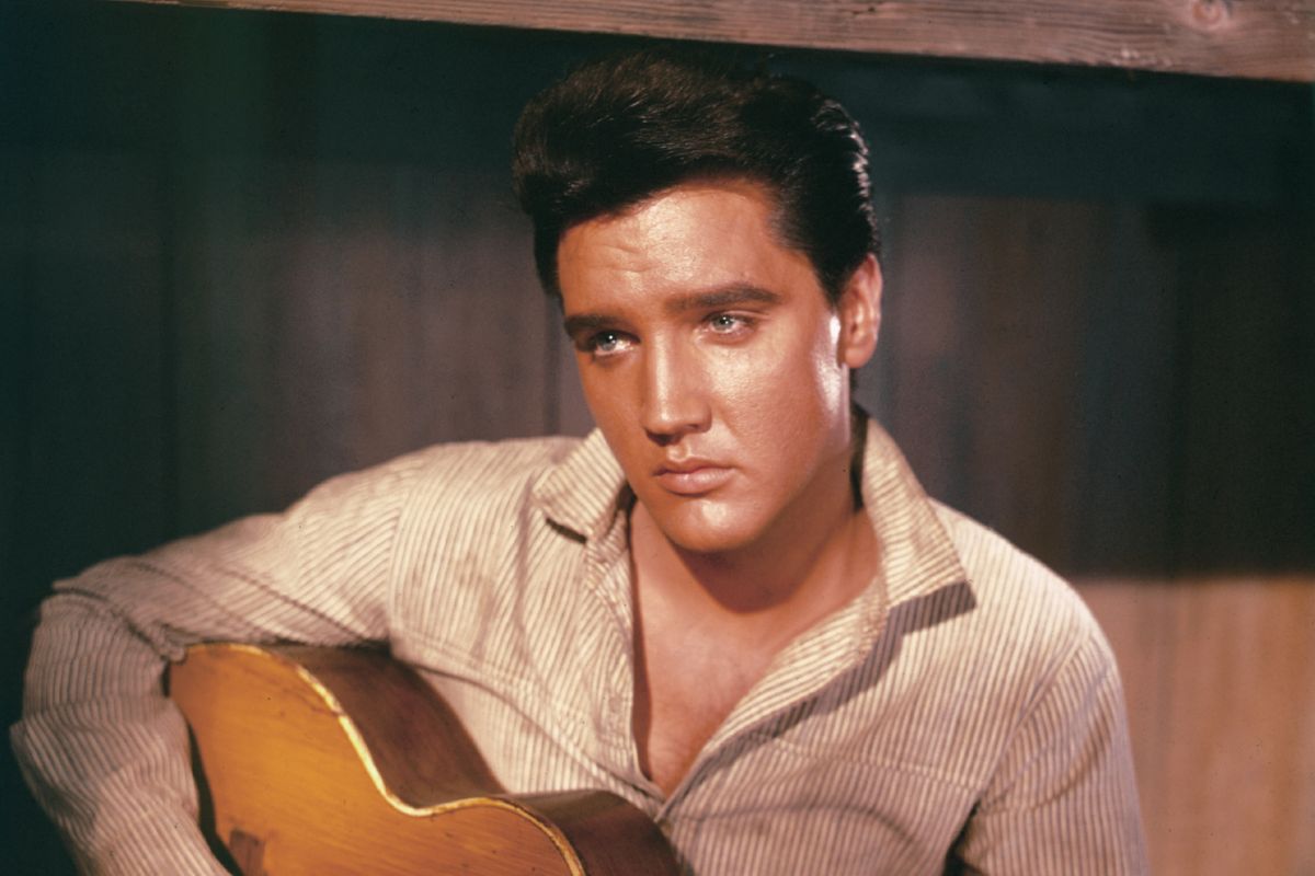 Elvis Presley A portrait of American singer and actor Elvis Presley holding an acoustic guitar circa 1956.