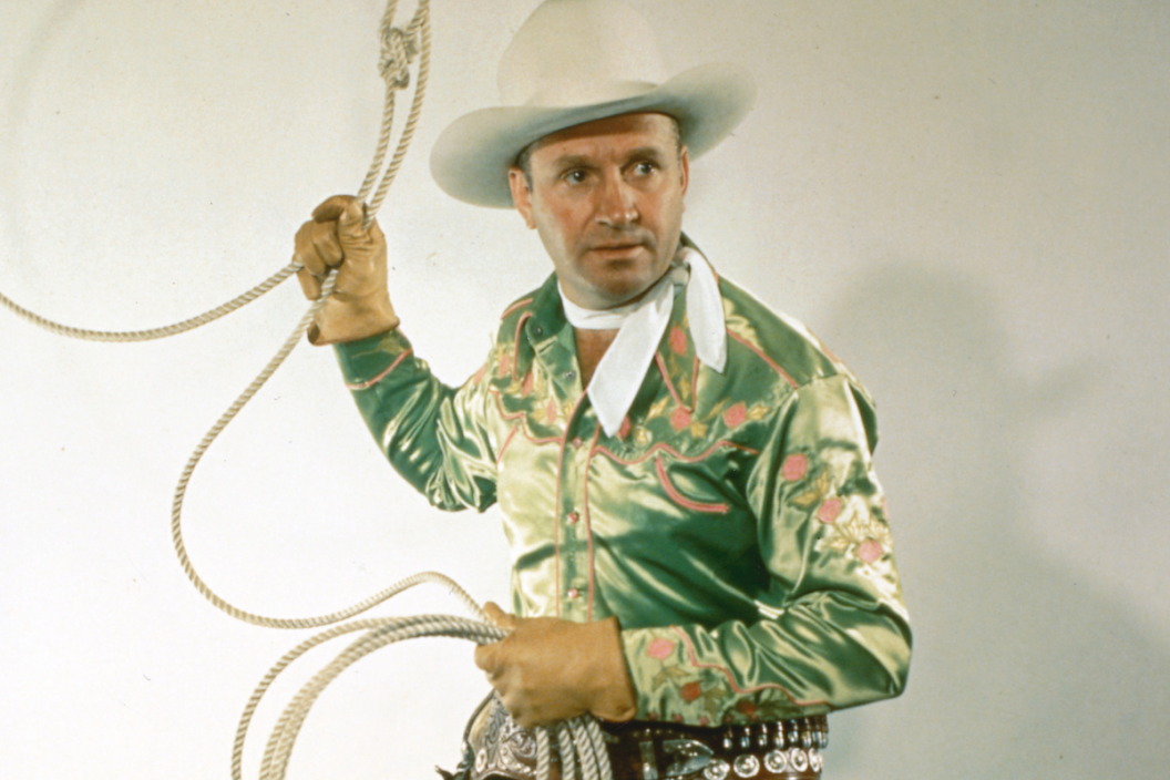Gene Autry (1907-1998), US singer and actor, in costume and holding a lassoo in a studio portrait, USA, circa 1950. Autry gained fame as 'The Singing Cowboy' on radio, in the movies and on television.