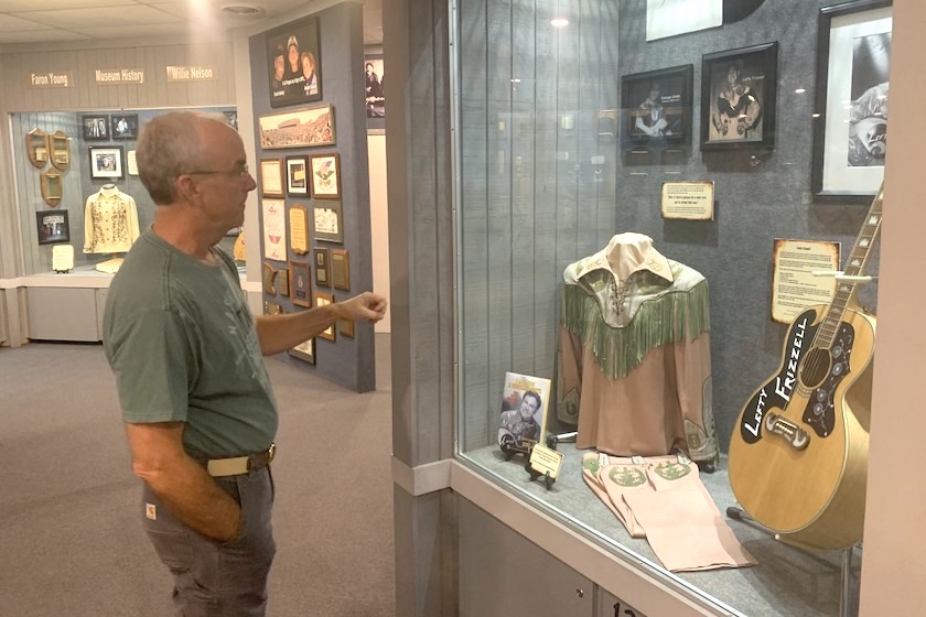 Mark Hughes explains an object in a display themed around Lefty Frizzell.