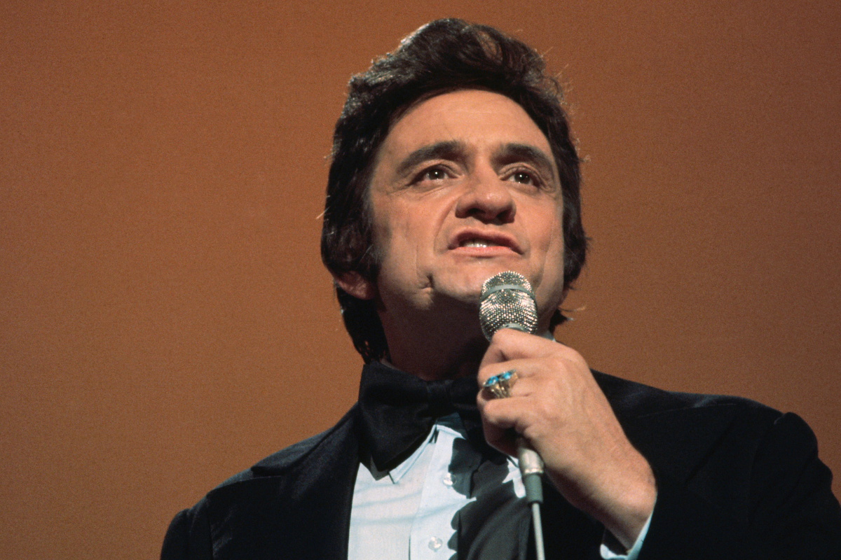 Low-angle close-up photograph of country/western singer Johnny Cash during a performance.