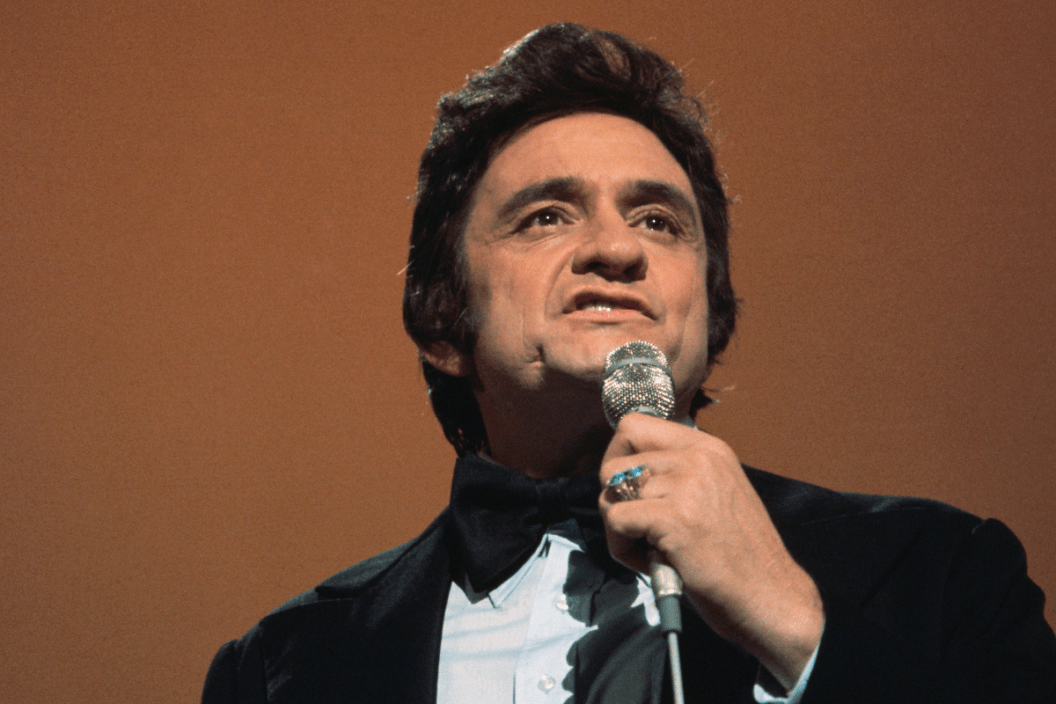 Low-angle close-up photograph of country/western singer Johnny Cash during a performance.