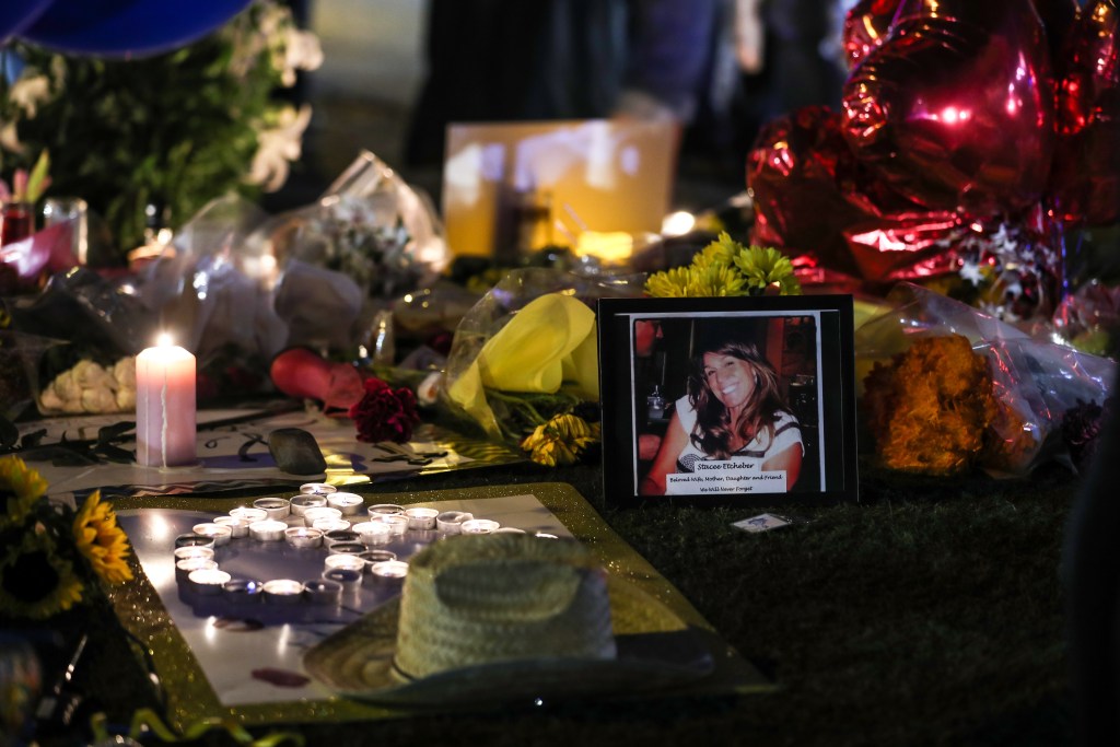 People light candles, place figures and flowers at a makeshift memorial set up along the Las Vegas Strip for the Las Vegas mass shooting victims