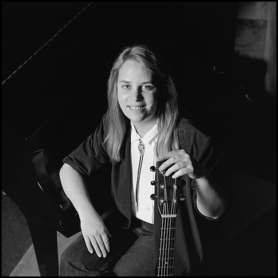 Portrait of American Country musician Mary Chapin Carpenter, with her guitar, as she poses at the Birchmere, Alexandria, Virginia, January 16 or 17, 1987.