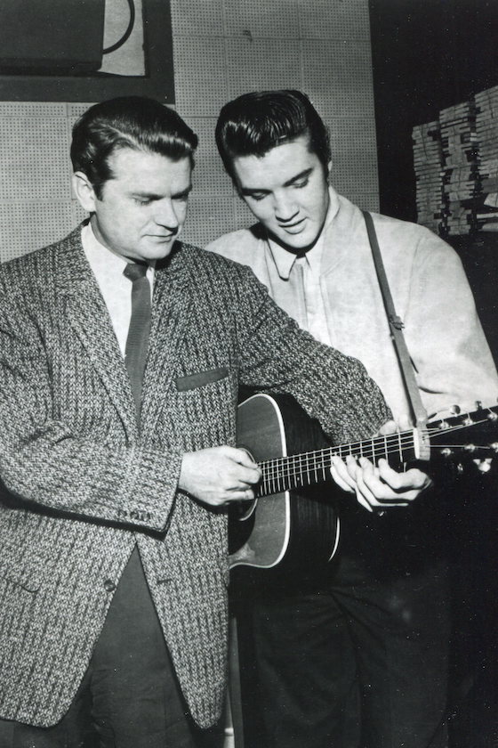 Sun Records owner Sam Phillips and Elvis Presley both fingering a chord on the same guitar, United States, 1956. 