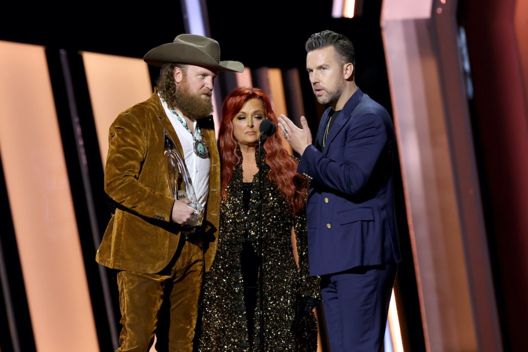 NASHVILLE, TENNESSEE - NOVEMBER 09: John Osborne, Wynonna Judd and T.J. Osborne speak onstage at The 56th Annual CMA Awards at Bridgestone Arena on November 09, 2022 in Nashville, Tennessee.