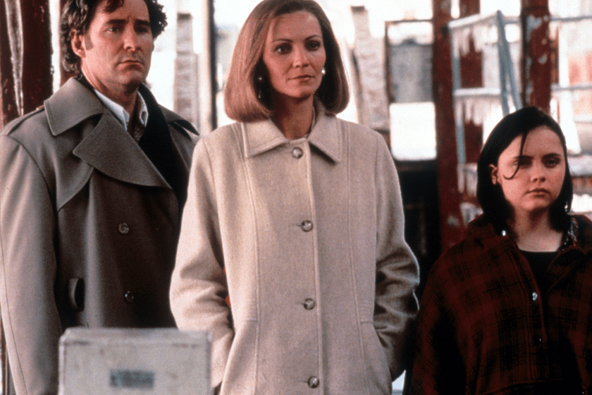 Kevin Kline, Joan Allen and Christina Ricci all standing on a sidewalk, wearing coats and staring in the same direction in a scene from the film 'The Ice Storm', 1997