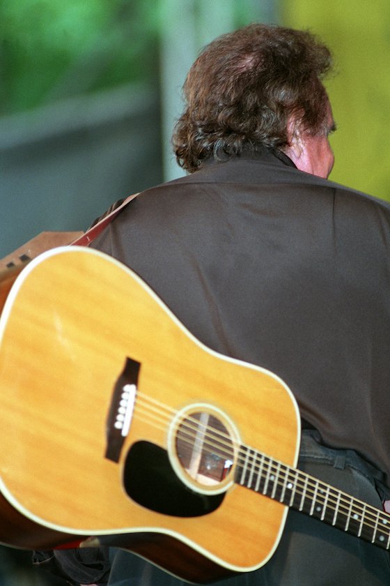 Für Kenner auch mit geschulterter Gitarre und von hinten unverkennbar: Der US-amerikanische Country & Western Superstar Johnny Cash, aufgenommen während eines Konzerts am Kölner Tanzbrunnen am 7. Juli 1994. 