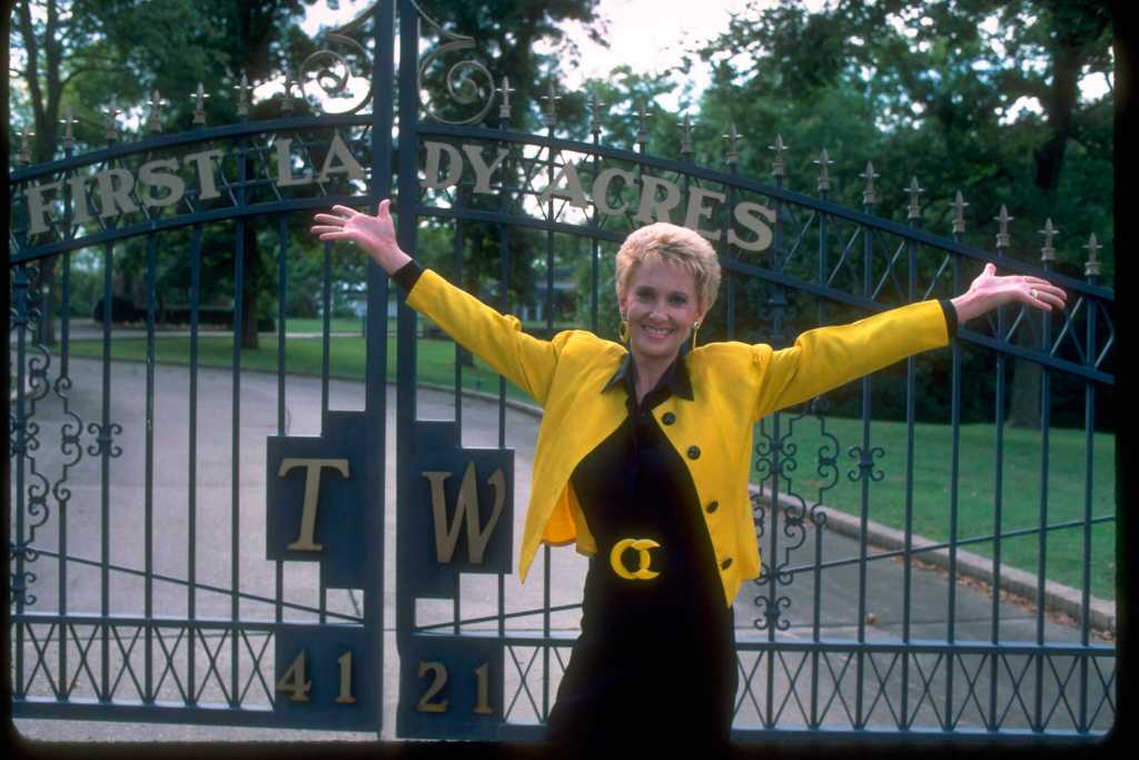 American country music singer and musician Tammy Wynette photographed by the gates of her 'First Lady Acres' home in Nashville, Tennessee, circa 1987.