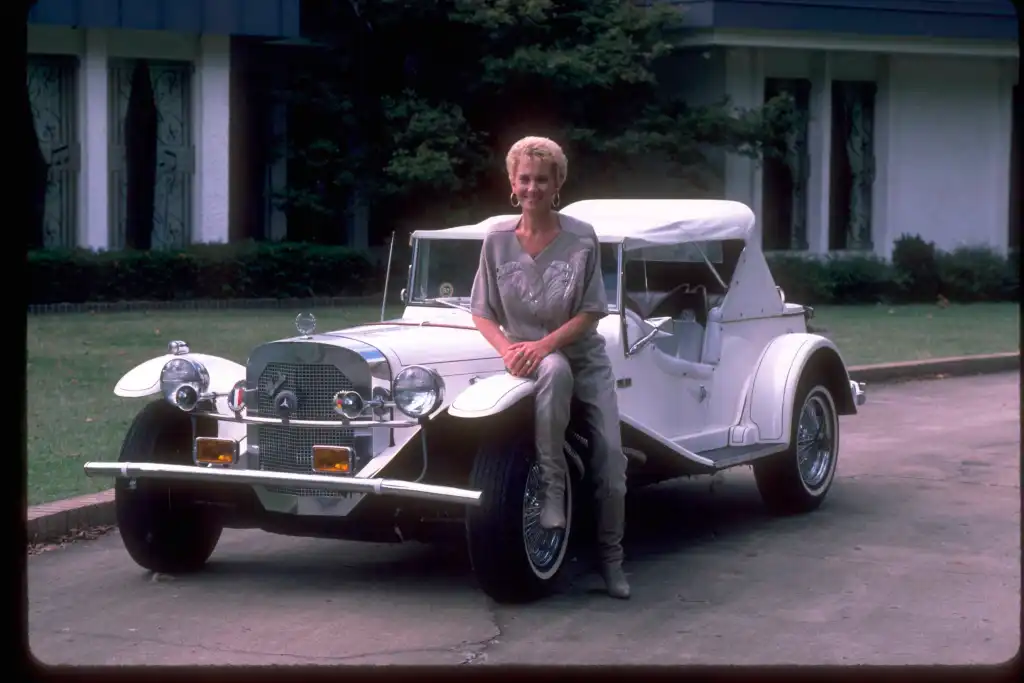 American country music singer and musician Tammy Wynette photographed with a vintage Mercedes-Benz at her 'First Lady Acres' home in Nashville, Tennessee, circa 1987. 