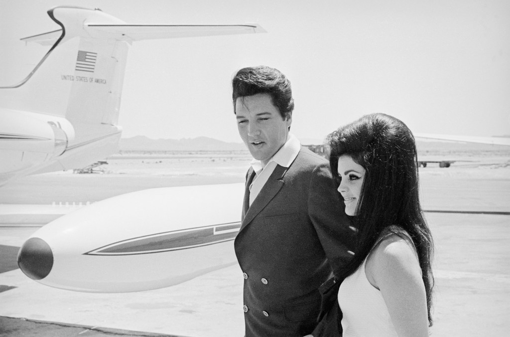 (Original Caption) Singer Elvis Presley and his bride Priscilla Ann Beaulieu smile happily as they prepare to board a chartered jet airplane after their marriage at the Aladdin Hotel. The couple met while Presley was in the Army.