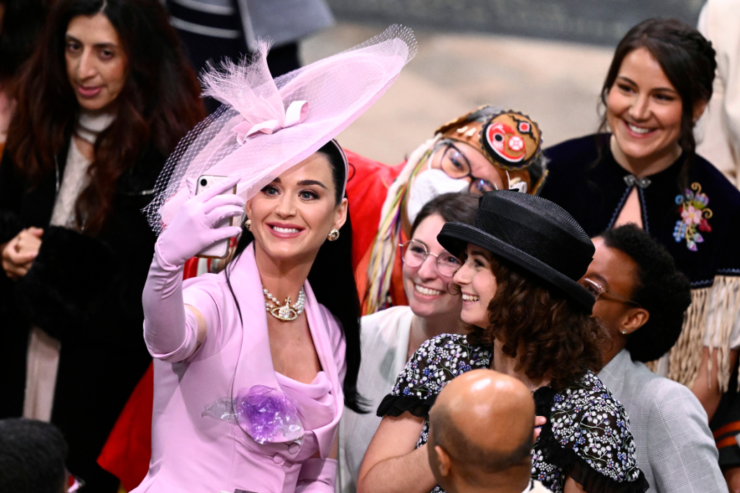 LONDON, ENGLAND - MAY 06: Katy Perry takes selfies with guests during the Coronation of King Charles III and Queen Camilla on May 06, 2023 in London, England. The Coronation of Charles III and his wife, Camilla, as King and Queen of the United Kingdom of Great Britain and Northern Ireland, and the other Commonwealth realms takes place at Westminster Abbey today. Charles acceded to the throne on 8 September 2022, upon the death of his mother, Elizabeth II.