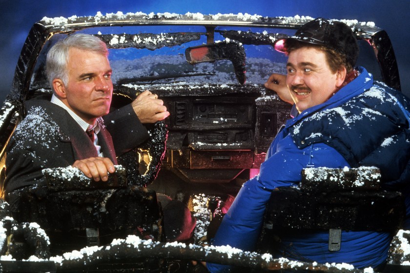 Steve Martin and John Candy sit in a destroyed car in a scene from the film 'Planes, Trains & Automobiles', 1987. 