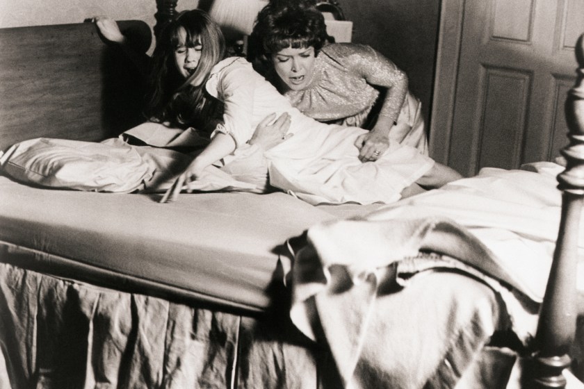 (Original Caption) 1973- Picture shows actress, Ellen Burstyn(R), struggling to keep her daughter, actress Linda Blair(L), in her bed during a scene from the 1973 movie "The Exorcist".