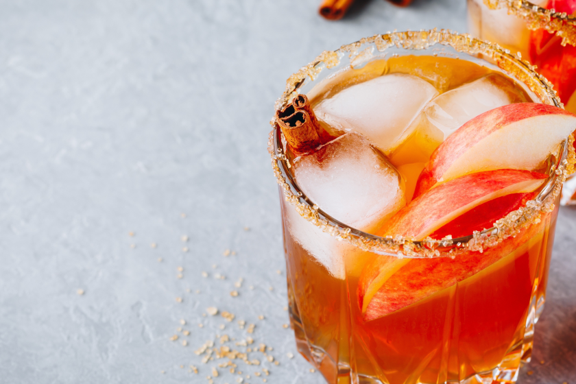 Chai spiced Apple cider cocktail for Halloween or Thanksgiving in glass on gray stone background