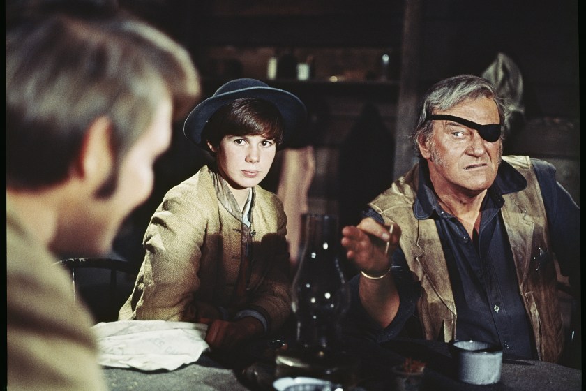 UNITED STATES - CIRCA 1969: John Wayne points ominously at Glen Campbell, while sitting next to the actress Kim Darby in this scene from the western "True Grit", 1969.
