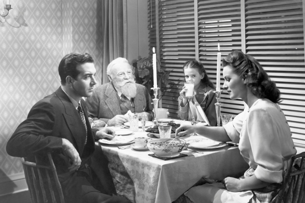 Fred Gailey (actor John Payne), Kris Kringle (actor Edmund Gwen), Doris Walker (actress Maureen O'Hara) and Susan Walker (actress Natalie Wood) sit at the diner table during a scene from the 1947 20th Century Fox production of "A Miracle on 34th Street."