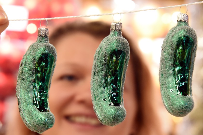 08 November 2022, Saxony-Anhalt, Spickendorf Bei Halle/Saale: Managing director Alexandra Häder holds glass cucumbers as Christmas tree ornaments in her hands in her ceramics barn in Spickendorf near Halle. In the USA, it is a widespread custom to hang the so-called "Christmas Pickle" somewhat hidden in the branches as the last tree ornament. Whoever finds it first receives an extra Christmas present and good luck in the coming year. Already since August, the "Christmas Wonderland" has been set up in their barn on about 800 square meters and is now supplemented with new Christmas decorations. Several thousand Christmas decoration artefacts are intended to get customers in the mood for the festive season. With suggestions for decorating the Christmas parlor and the festive dining table, Alexandra Häder wants to encourage a stress-free and peaceful gathering of the whole family.