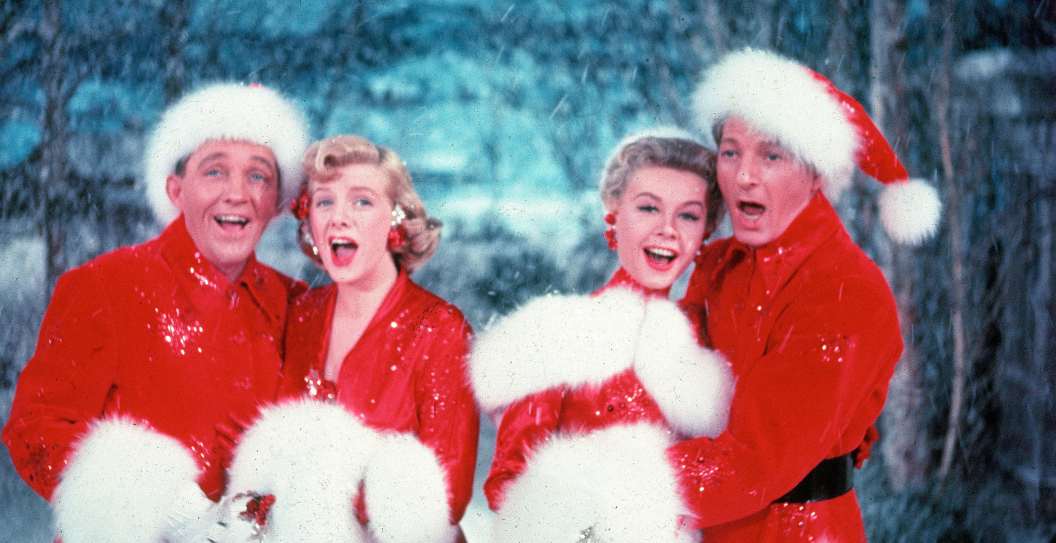 American actors Bing Crosby (1903 - 1977), Rosemary Clooney (1928 - 2002), Vera-Ellen (1921 - 1981), and Danny Kaye (1913 - 1987) sing together, while dressed in fur-trimmed red outfits and standing in front of a stage backrop, in a scene from the film 'White Christmas,' directed by Michael Curtiz, 1954