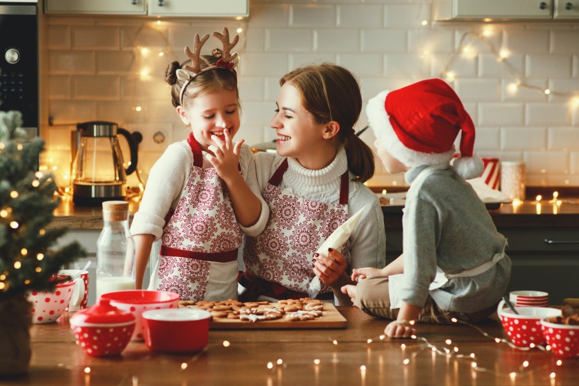 Happy funny family mother and children bake christmas cookies