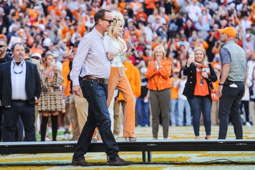 KNOXVILLE, TN - NOVEMBER 18: Peyton Manning walks with Dolly Parton during a college football game between the Tennessee Volunteers and the Georgia Bulldogs on November 18, 2023, at Neyland Stadium, in Knoxville, TN. 