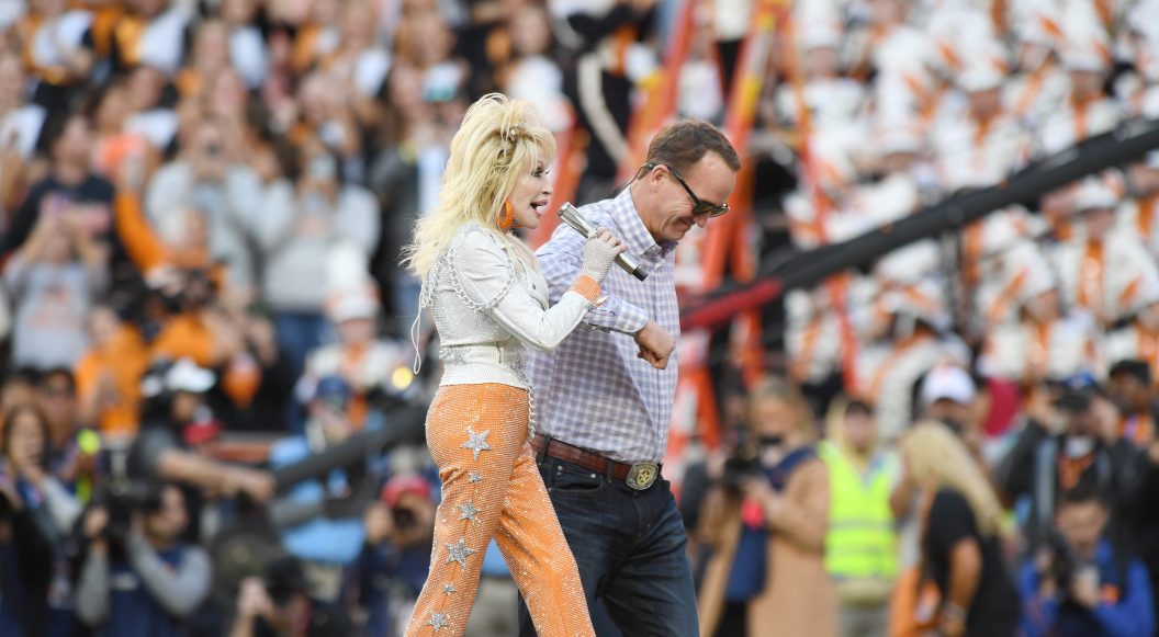 KNOXVILLE, TN - NOVEMBER 18: Dolly Parton walks off the field with Peyton Manning during the college football game between the Georgia Bulldogs and the Tennessee Volunteers on November 18, 2023, at Neyland Stadium in Knoxville, TN.