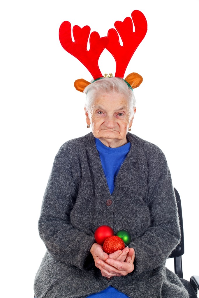 Portrait of an elderly woman wearing Christmas decoration on an isolated background.