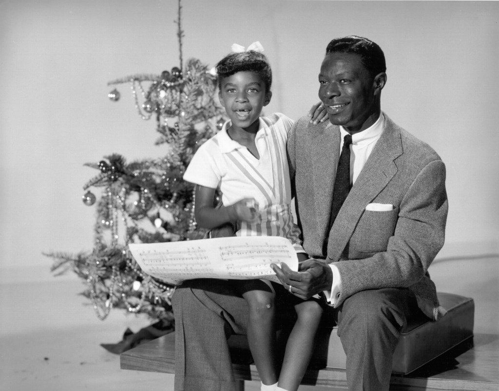 Natalie Cole and Nat King Cole in front of a Christmas tree.