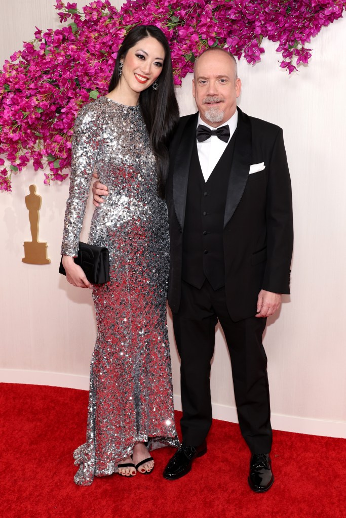 HOLLYWOOD, CALIFORNIA - MARCH 10: (L-R) Clara Wong and Paul Giamatti attend the 96th Annual Academy Awards on March 10, 2024 in Hollywood, California. 
