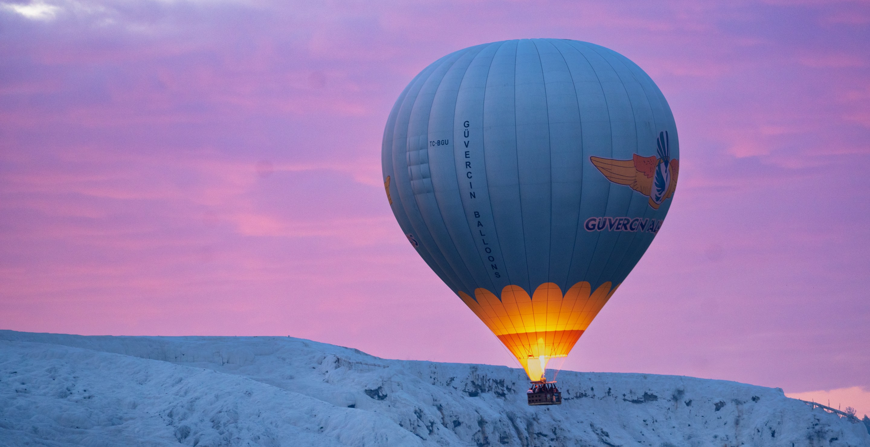 DENIZLI, TURKIYE - APRIL 01: Hot air balloons rise over UNESCO World Heritage Site Pamukkale at sunrise in Denizli, Turkiye on April 01, 2026. As dozens of balloons rise into the sky in the early morning hours, gliding over the white travertine terraces and the ancient city of Hierapolis, hot air balloon tours, which have recently seen a surge in popularity, continue to be one of the important symbols of tourism activity in the region. (Photo by Aysegul Kurt/Anadolu via Getty Images)
