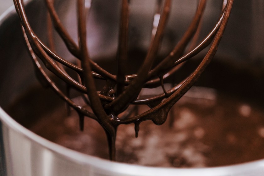 Chocolate immersed whisk close up view. recipe and bakery concept