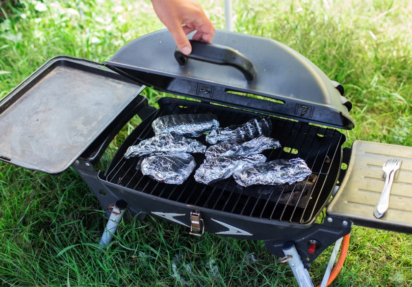 Cooking fish in foil on barbecue.