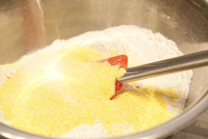 Cornmeal over flour in a mixing bowl