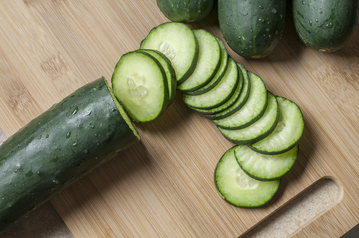 Fresh cucumber slices on a wooden cutting board