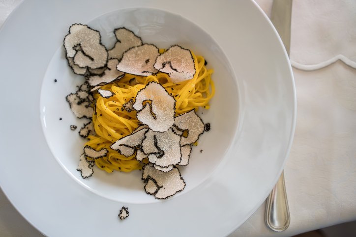 Handmade fresh egg pasta with black truffle serving in Italy