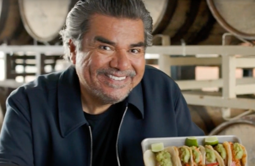 George Lopez holding tacos