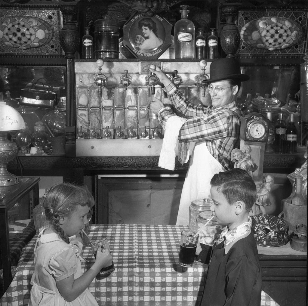 circa 1950:  Two children drinking root beer in Wilfred Allen's county store in Sudbury, Massachusetts. It was the first soda fountain installed in New England, in 1881.  