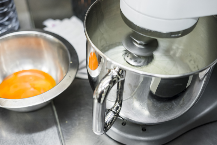 Whipping egg whites in professional kitchen mixer in a restaurant