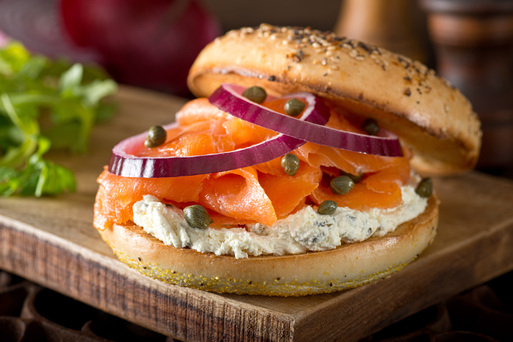A delicious toasted bagel with smoked salmon, cream cheese, capers, and red onion.