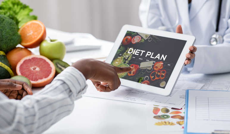 Dietologist Doctor Holding Digital Tablet With Opened Diet Plan