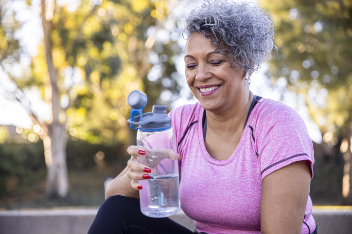 A woman hydrating after her workout.