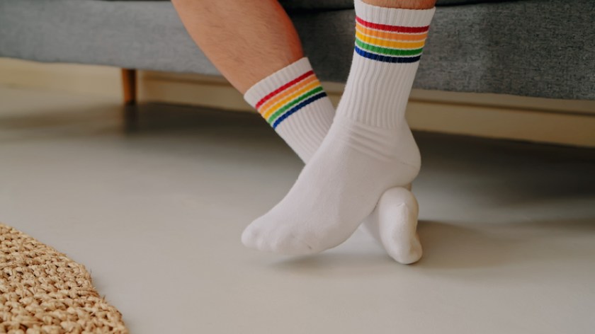 Cropped shot of a man wearing rainbow coloured socks while relaxing on the sofa at home