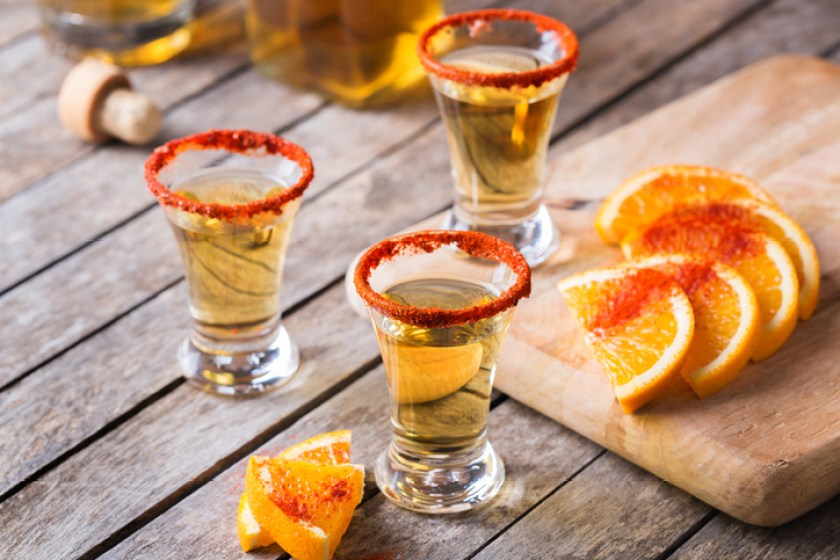 Mexican mezcal or mescal shot with chili pepper and slice of orange. Typical alcohol beverage made from all types of agave unlike tequila in mexico