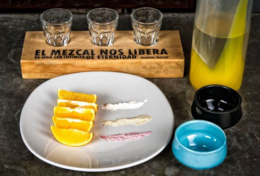 Espadin mezcal with cuish (a variety of agave) served with a dish with orange slices and three different flavors of sea salt - hibiscus, penny royal mint and agave worm - at the Zandunga restaurant which offers traditional Tehuantepec Isthmus cuisine in Oaxaca, Mexico on March 1, 2017. / AFP PHOTO / Omar TORRES        (Photo credit should read OMAR TORRES/AFP via Getty Images)