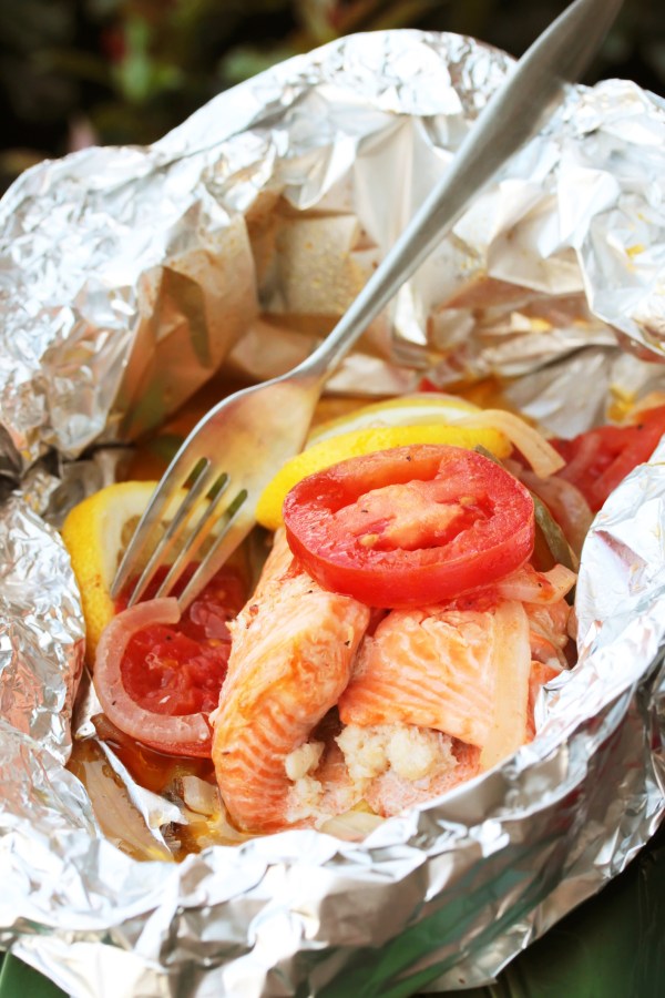 Vertical image of fish grilled in a foil packet.