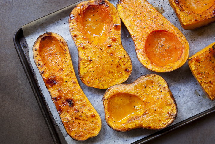 Roasting butternut pumpkin, for a warming soup. Top view on oven tray.