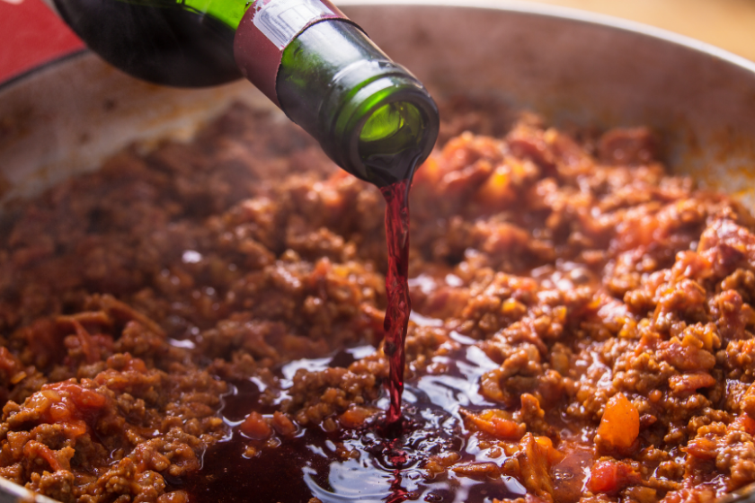 wine being poured into beef dish