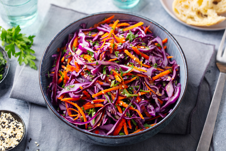 Red cabbage salad. Coleslaw in a bowl. Grey background. Close up