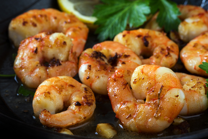 prawns shrimps roasted in a black pan with garlic,